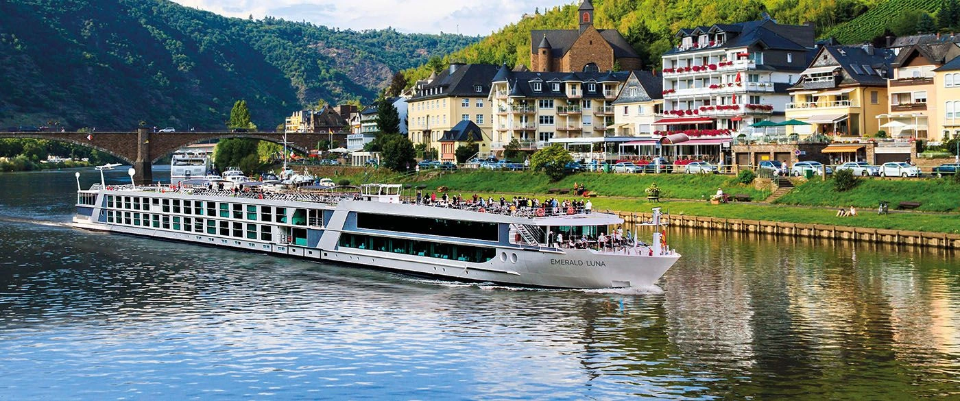 Emerald Luna river ship passing a European riverside village