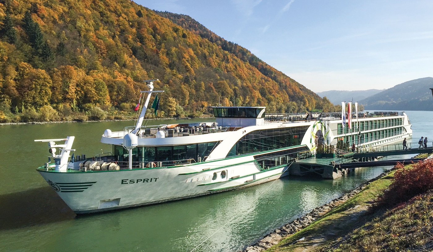 Tauck ms Esprit river ship beside an autumn hillside